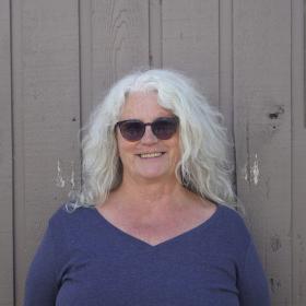 Smiling woman with glasses and a blue shirt